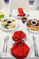 Red serviette lies on white dinner plates