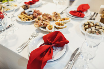 Red serviette lies on white dinner plates