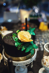 Black glaze cake decorated with golden rose