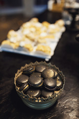 Black macaroons in silver bowl