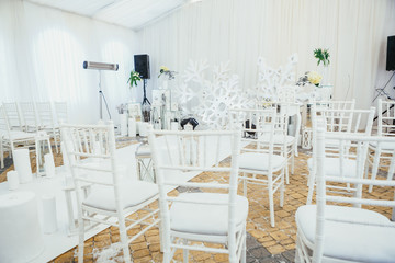 White chairs stand before the wedding altar decorated with snowflakes