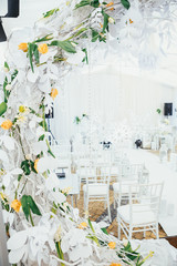 Large wreath of white branches stands before the path to wedding altar