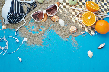 Fototapeta na wymiar Summer background. Beach vacation accessories flat lay on sand with seashells and azure colour texture. Resort mood and relax holiday. 