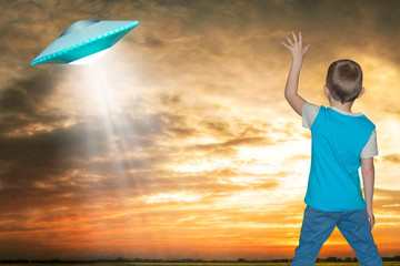 The little boy looks up at an unidentified flying object which appeared in the sky.	