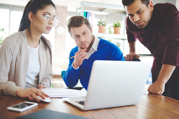 Three young business people over work .