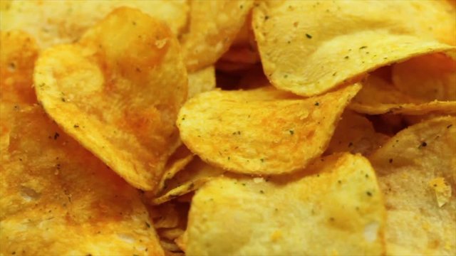 Potato chips food background. Closeup of slowly rotating potato chips
