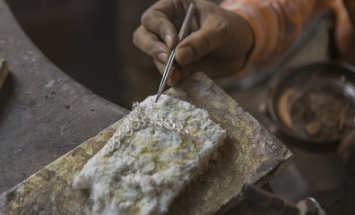 Indian Jeweler making an Oriental Jewelry in workshop. Handmade traditional jewel Manufacturing in...