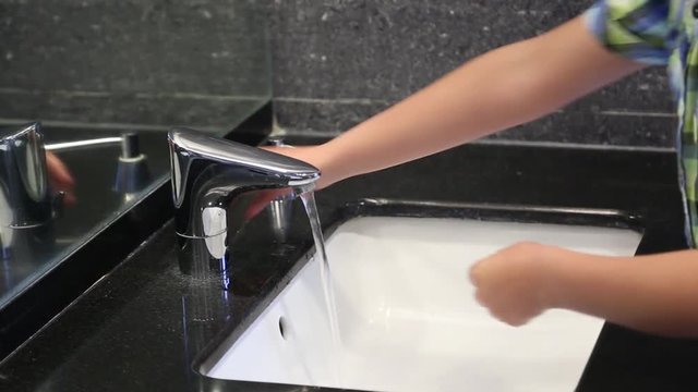 Child washing hands with soap. Real time full hd video footage.