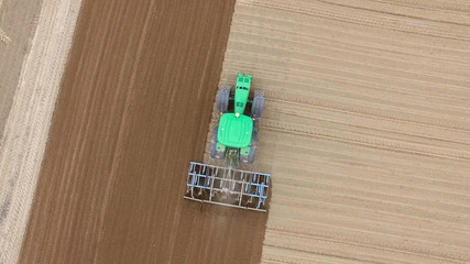 tractor - aerial view of a tractor at work - cultivating a field in spring - agricultural machinery