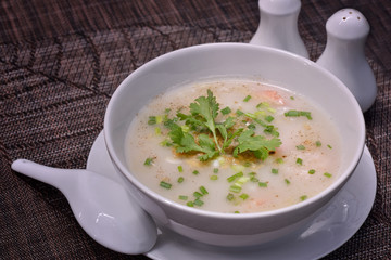Rice porridge with shrimp in white bowl.