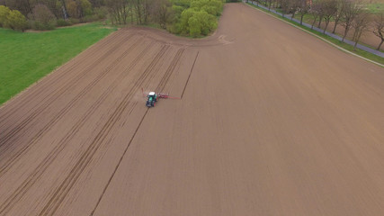 tractor - aerial view of a tractor at work - cultivating a field in spring - agricultural machinery