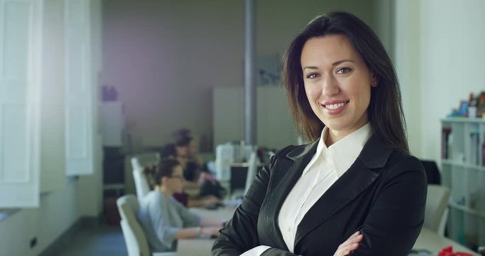 Successful business woman in the office, smiling at the camera, trading and selling (stock). Concept: career growth, work in the office, business affairs,marketing, achievement,colleagues and partners
