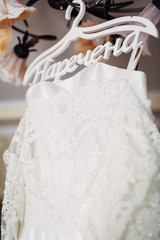 The wedding dress hangs on the hanger
