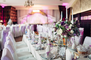 The vase with flowers and frame with number standing on the table