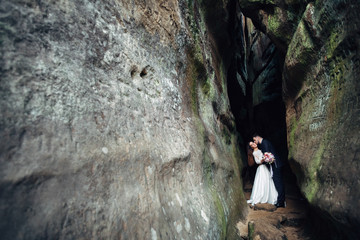 The lovely couple in love embarcing near stones