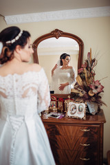 The charming bride looking at mirror