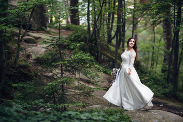 The beautiful bride standing on the stones