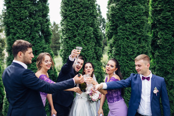 The brides,bridesmaids and groomsmen keeping glasses  of champagne