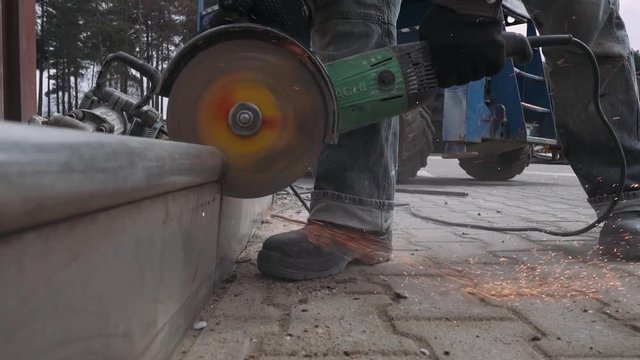  Worker cutting the metal structure through angular grinding machine. 60fps. Close-up. 
