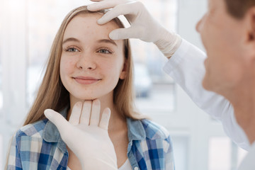 Careful dermatologist examining patient face at work - obrazy, fototapety, plakaty