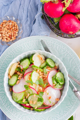 Salad from potatoes, radishes, cucumbers with pine nuts, top view