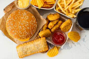 Junk food on white table. Fast carbohydrates not good for health, heart and skin