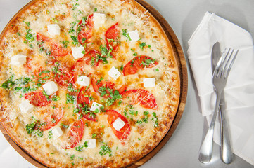 Top view Four cheese pizza quattro fromaggi on a rustic wooden board on the table with ingridients. Selective fovus