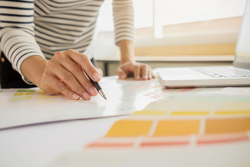 Graphic design and color swatches and pens on a desk. Architectural drawing with work tools and accessories.