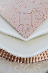 Fototapeta na wymiar Look from above at card with delicate design lying on dinner plates