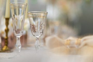 Crystal glasses with golden design stand on dinner table