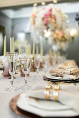 Fototapeta premium Crystal glasses stand by the plates on fancy served dinner table
