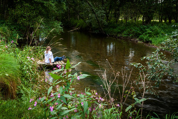 A young girl sitting by the water