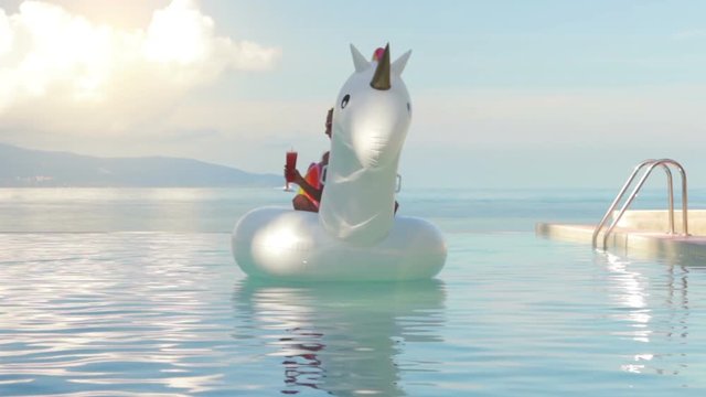 Attractive woman lying on Inflatable unicorn in swimming pool on sea background