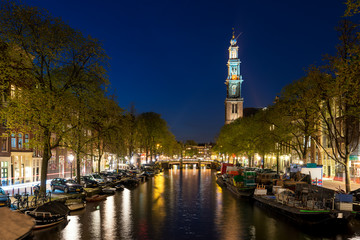 Amsterdam Westerkerk church tower at canal in the city of Amsterdam, Netherlands.