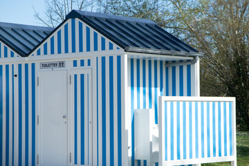 beautiful blue and white cabin that serves as a toilet in the park - obrazy, fototapety, plakaty