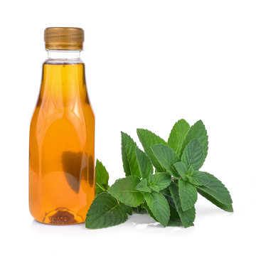 Bottle of honey and Fresh mint leaves isolated on white