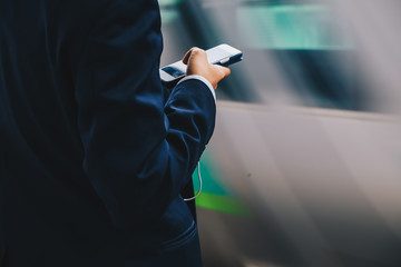 Business man use cellphone at railway station