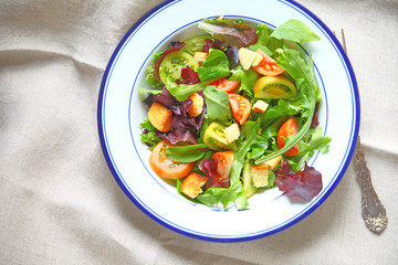 Salad with miniature heirloom tomatoes, mixed young lettuces and croutons with copy space