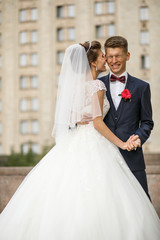 Fototapeta premium Bride leans to groom tender posing outside