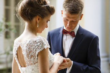 Groom looks at bride's hands holding them tender