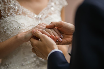 Groom fixes wedding ring on bride's finger
