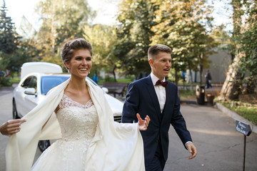 Cheerful newlyweds walk out from the car