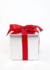 Silver gift box with red ribbon bow.