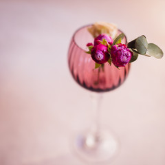 Tiny rose buds put in violet glass