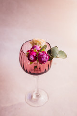 Tiny rose buds put in violet glass