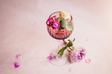Obraz na płótnie Canvas Violet hydrangea lies beneath glass with pink rose buds