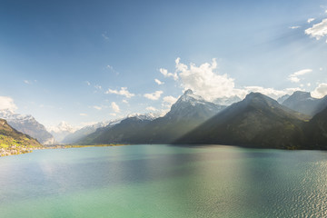 Mountain landscape in the Alps and lake. Gorgeous scenery of mountain landscape in contrasting light. The water of the lake in bright sunlight has a green turquoise color. Polarizing filter.