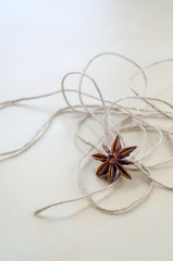 Dried cloves and twine on a wooden Board closeup