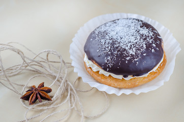 Cake with chocolate and coconuts decorated with dried cloves and twine.
