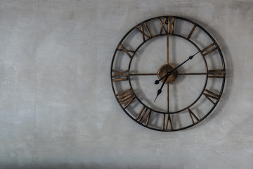 Classic clock on raw concrete wall background